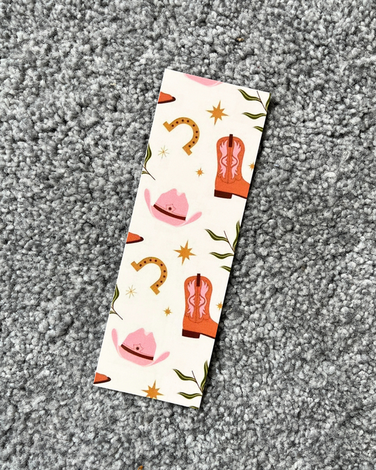 A bookmark with a cowboy boot design and various colorful illustrations on a glossy card background.